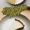 Collage featuring a pistachio tart with a slice removed to show the interior, and a close-up of a single tart slice on a ceramic plate, capturing the rich pistachio filling and crisp cookie crust.