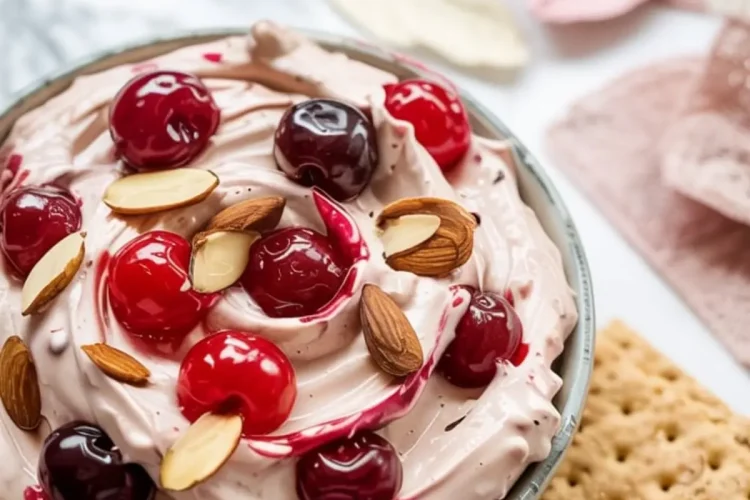 Cherry almond dip served in a bowl with graham crackers, garnished with whole cherries and almonds, with text overlay reading “Cherry Almond Dip – Dip it, love it, done.”
