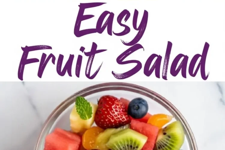 Close-up of a vibrant fruit salad in a white bowl featuring cubed watermelon, sliced kiwi, pineapple chunks, whole blueberries, strawberries, mandarin orange segments, and fresh mint leaves.