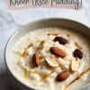 A bowl of Indian rice pudding garnished with almonds, raisins, and saffron strands, with overlay text reading “Easy Indian Dessert - Kheer (Rice Pudding)” on a light marble background.
