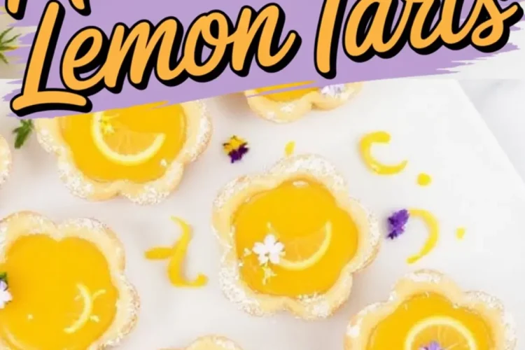 Decorative mini flower-shaped lemon tarts with bright yellow filling and powdered sugar edges, garnished with lemon slices and edible flowers on a white platter.