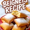 Golden, fluffy beignets stacked on a red plate and dusted with powdered sugar, with the text “Beignets Recipe” displayed above.