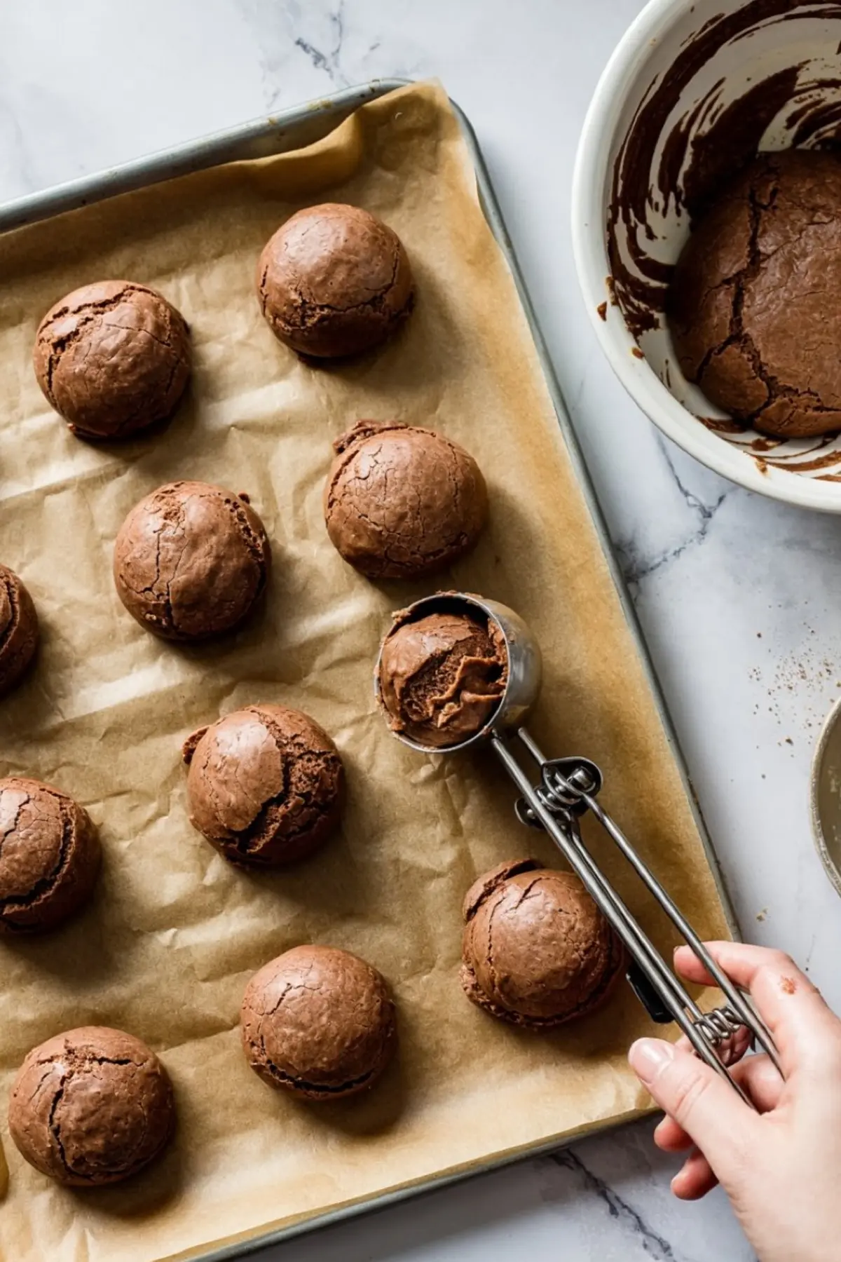 Scoopable brownie mix cookie dough on a baking tray with parchment paper, showing how to portion batter for brownie mix cookies. Ideal for Box Brownie Cookies Recipes and Brownie Bites From Mix Boxes.