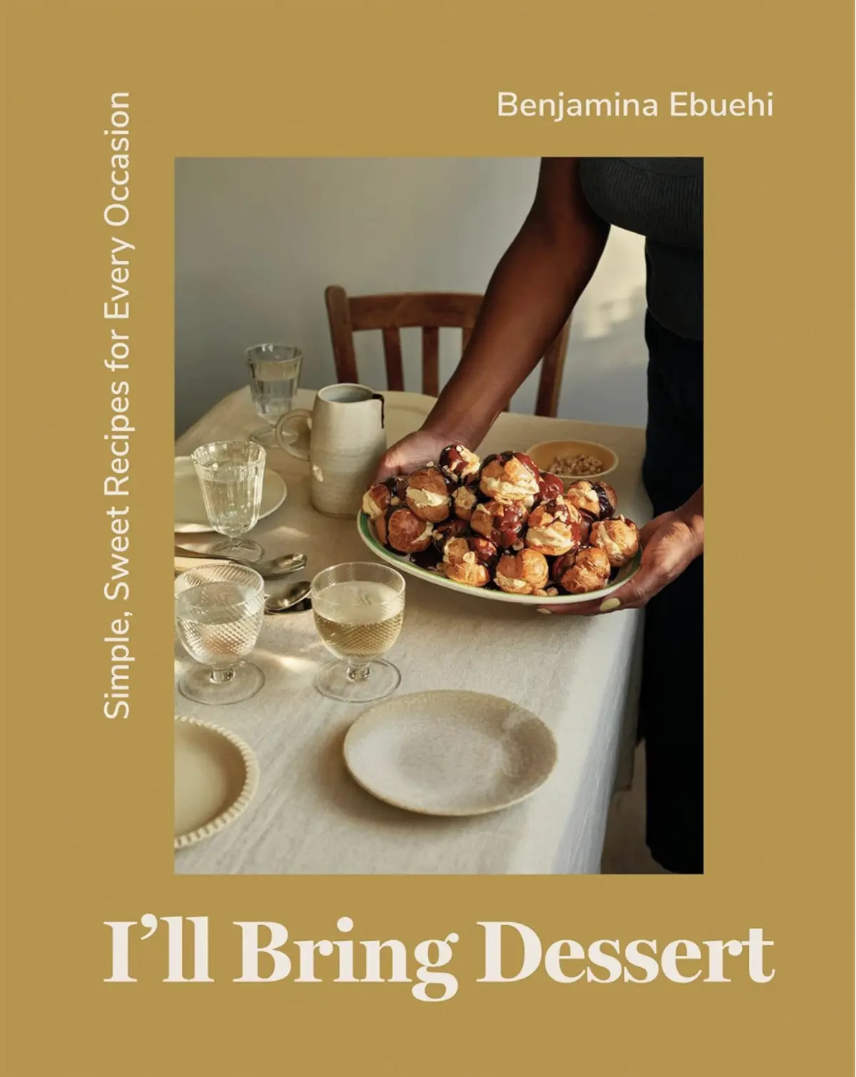 “I’ll Bring Dessert” by Benjamina Ebuehi cover showing a woman setting down a platter of cream puff profiteroles drizzled with chocolate, surrounded by an elegant table setting with neutral-toned dishes.