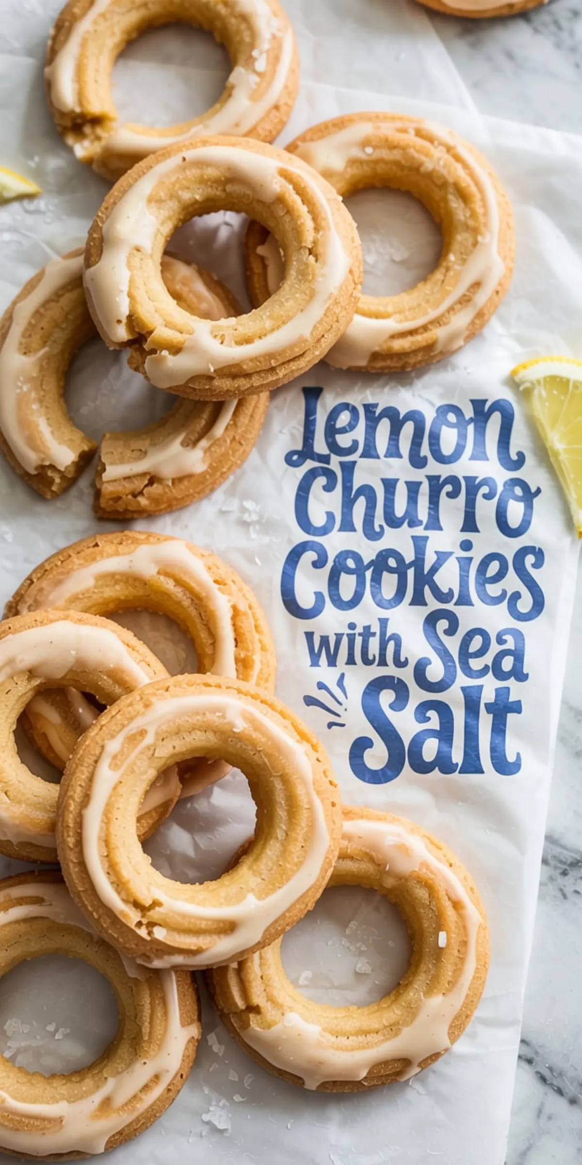Lemon churro cookies displayed on parchment paper, some broken to show texture, all topped with icing and sea salt, paired with lemon wedges for a rustic and fresh cookie presentation.
