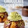 Close-up of a pistachio chocolate choux bun topped with glossy chocolate glaze, piped pistachio cream, and chopped pistachios, with bold text overlay reading “Pistachio Chocolate Choux Buns.”