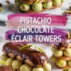 Three-tiered pistachio chocolate éclair towers filled with green pistachio cream puffs, stacked between crisp pastry layers and topped with glossy dark chocolate glaze and chopped pistachios on a marble surface.