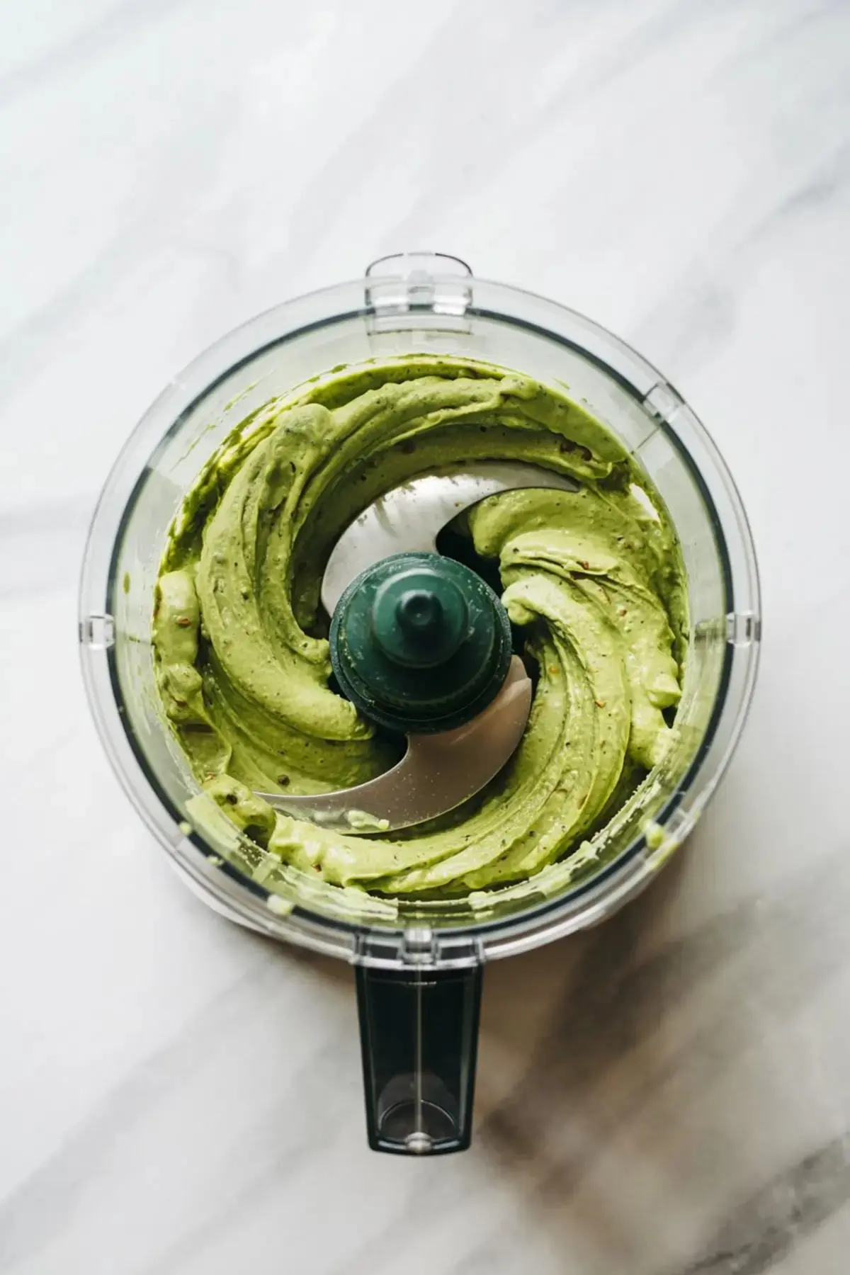  Food processor blending a smooth green pistachio cream mixture, ready to be used for layering in a pistachio chocolate sheet cake.