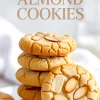 Stack of golden almond cookies with crackled tops and sliced almonds, with one cookie leaning against the stack, and text overlay reading “Best Almond Cookies” for recipe highlight.