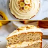 Close-up of a slice of banana cake with layers of cream cheese frosting and banana pieces, topped with banana slices, next to a full cake on a white plate.
