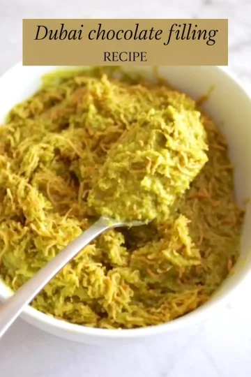 A white bowl filled with shredded green and golden vermicelli mixture labeled as “Dubai chocolate filling recipe,” showcasing a unique Middle Eastern dessert filling with a spoonful lifted for texture detail.