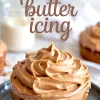 Peanut butter icing generously swirled on top of a small round cake, with text overlay reading “peanut butter icing” and blurred milk jar and additional cakes in the background.