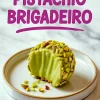 Pistachio brigadeiro with a bite taken out, showing its creamy green filling and coated in chopped pistachios, served on a small ceramic plate.