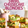 Stacked pistachio swirl cheesecake blondies with visible layers of cheesecake, green pistachio paste, and dense golden blondie base, displayed against a blurred kitchen background.