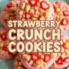 Plate of pink strawberry crunch cookies topped with chopped strawberries and golden cookie crumbles, arranged in a stack on a turquoise plate.