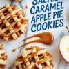 Flat lay of cookies with crisscross pie crust tops, oozing caramel and apple filling, text overlay reads “Salted Caramel Apple Pie Cookies,” one cookie has a bite taken out.