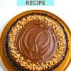 Whole chocolate peanut butter pie topped with glossy ganache and chopped peanuts on a dark cookie crust, presented on a mustard-colored plate with a recipe title above.