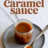 A jar of smooth homemade caramel sauce placed on a gray plate with a spoonful of caramel beside it, with the text “Homemade Caramel Sauce.”