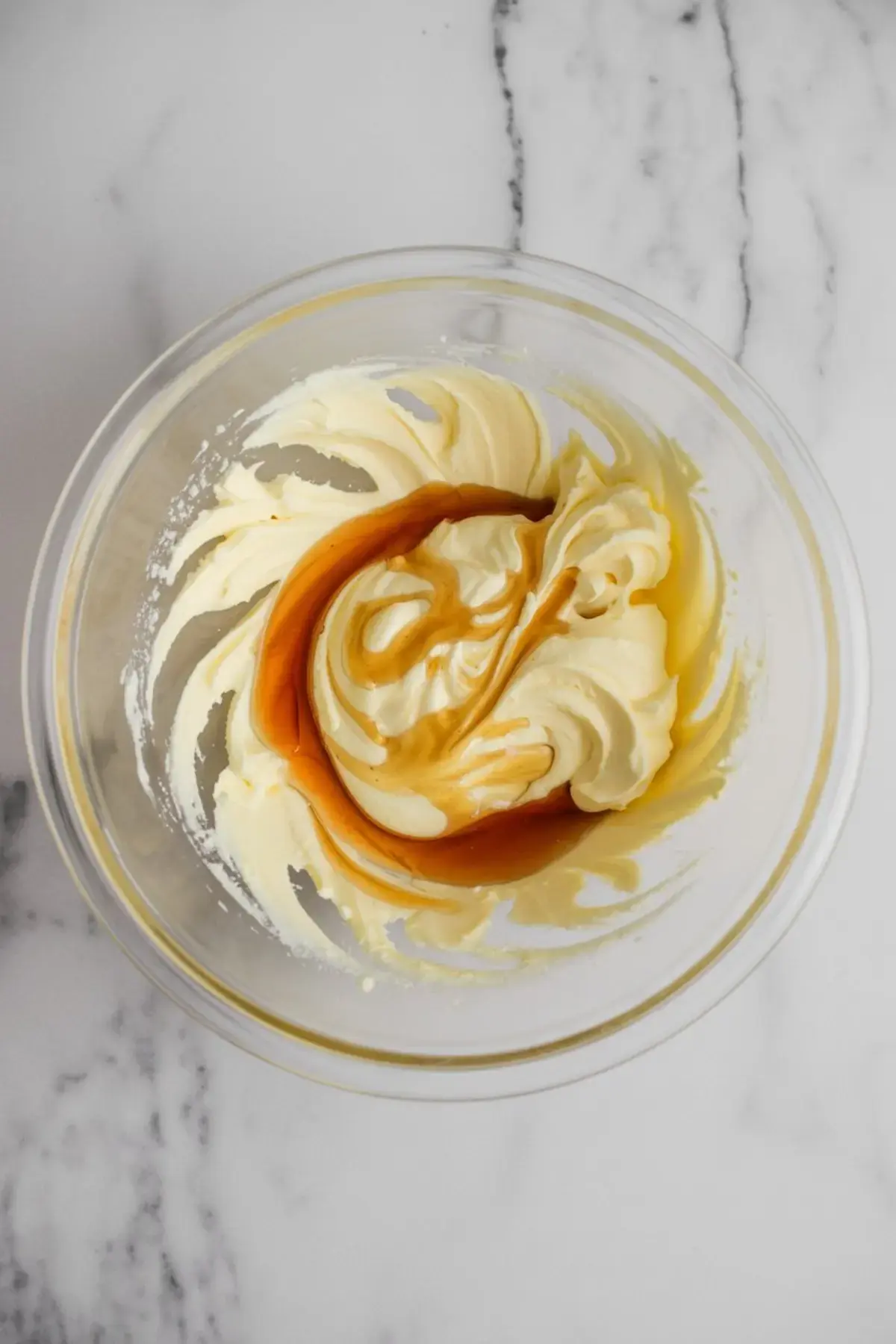 Mixing bowl with whipped butter swirled with maple syrup for homemade maple butter.
