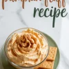 Overhead view of whipped pumpkin fluff served in a glass dish with a cinnamon sprinkle, styled with square graham crackers on a green plate and “pumpkin fluff recipe” text above on a marble background.