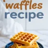 Stack of golden pumpkin waffles on a blue plate dusted with cinnamon powder, with text overlay reading “pumpkin waffles recipe” in bold orange and blue fonts.