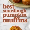 Overhead view of baked sourdough pumpkin muffins on a plate with one muffin sliced to show moist texture