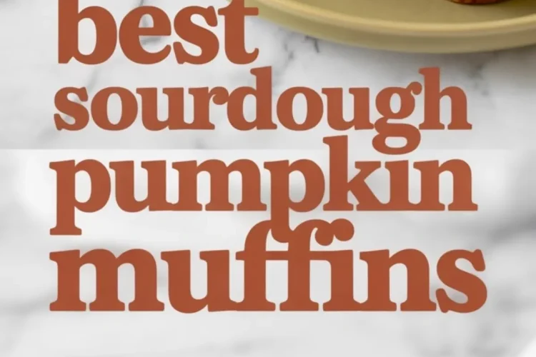 Overhead view of baked sourdough pumpkin muffins on a plate with one muffin sliced to show moist texture