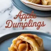 Close-up of golden apple dumplings baked in syrup, with one dumpling cut open to reveal tender spiced apple filling, served on a blue plate.