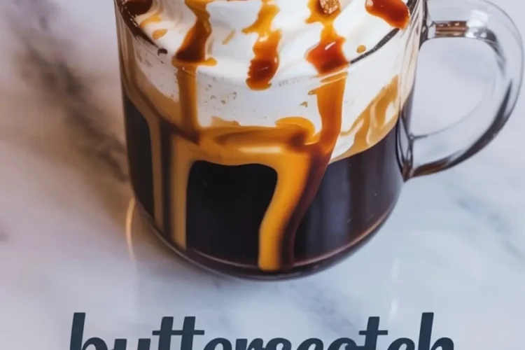 A clear glass mug of butterscotch coffee with swirled whipped cream, thick caramel drizzle, and light brown sugar chunks on a white marble background with “butterscotch coffee” text overlay.