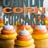 Close-up of frosted candy corn cupcakes topped with white, orange, and yellow buttercream swirls, styled beneath bold retro typography.