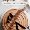 Overhead shot of a chocolate espresso cake with a slice cut out, showing smooth coffee frosting, dusted cocoa powder, and curled chocolate garnishes.