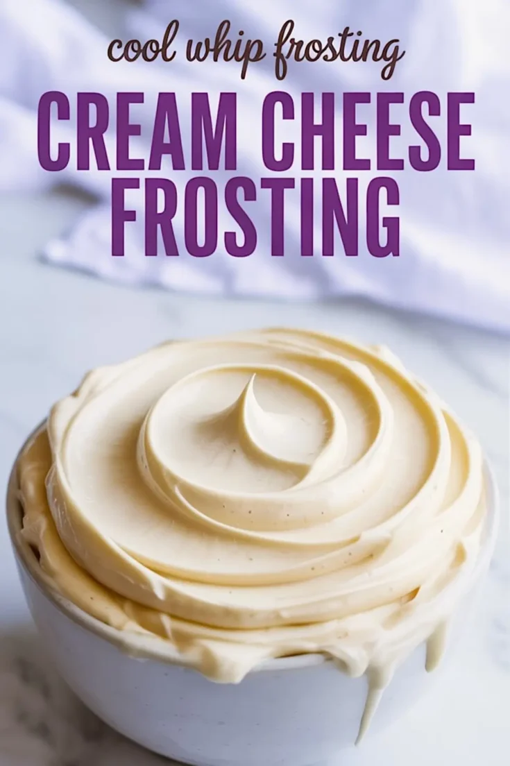 Thick Cool Whip cream cheese frosting with smooth peaks piped into a swirl inside a white bowl, dripping slightly over the sides on a white marble countertop with a soft cloth in the background.