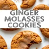 Top-down view of cracked ginger molasses cookies on a marble background, with two cookies partially eaten and a bold text overlay reading “Ginger Molasses Cookies.”