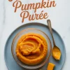 Glass bowl of creamy homemade pumpkin purée on a gray plate with pumpkin cubes, a spoon, and text overlay reading “Homemade Pumpkin Purée.”