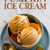 Blue ceramic bowl filled with scoops of pumpkin ice cream topped with cinnamon, placed on a matching plate with a gold spoon and decorative text reading “Pumpkin Ice Cream.”