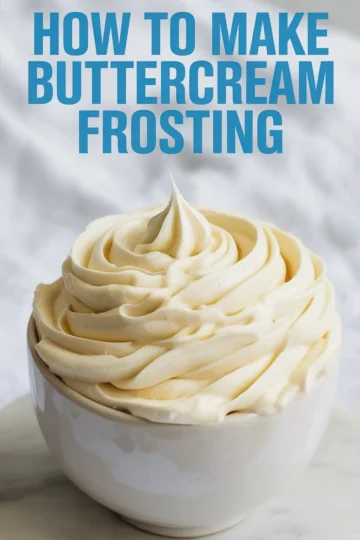 Bowl of fluffy vanilla buttercream frosting piped with ridged swirls, topped with a central peak, with text “How to Make Buttercream Frosting” above.