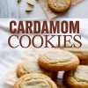 Collage image showing cardamom cookies on parchment paper next to whole green cardamom pods, with bold text reading “Cardamom Cookies” in the center on a marble background.