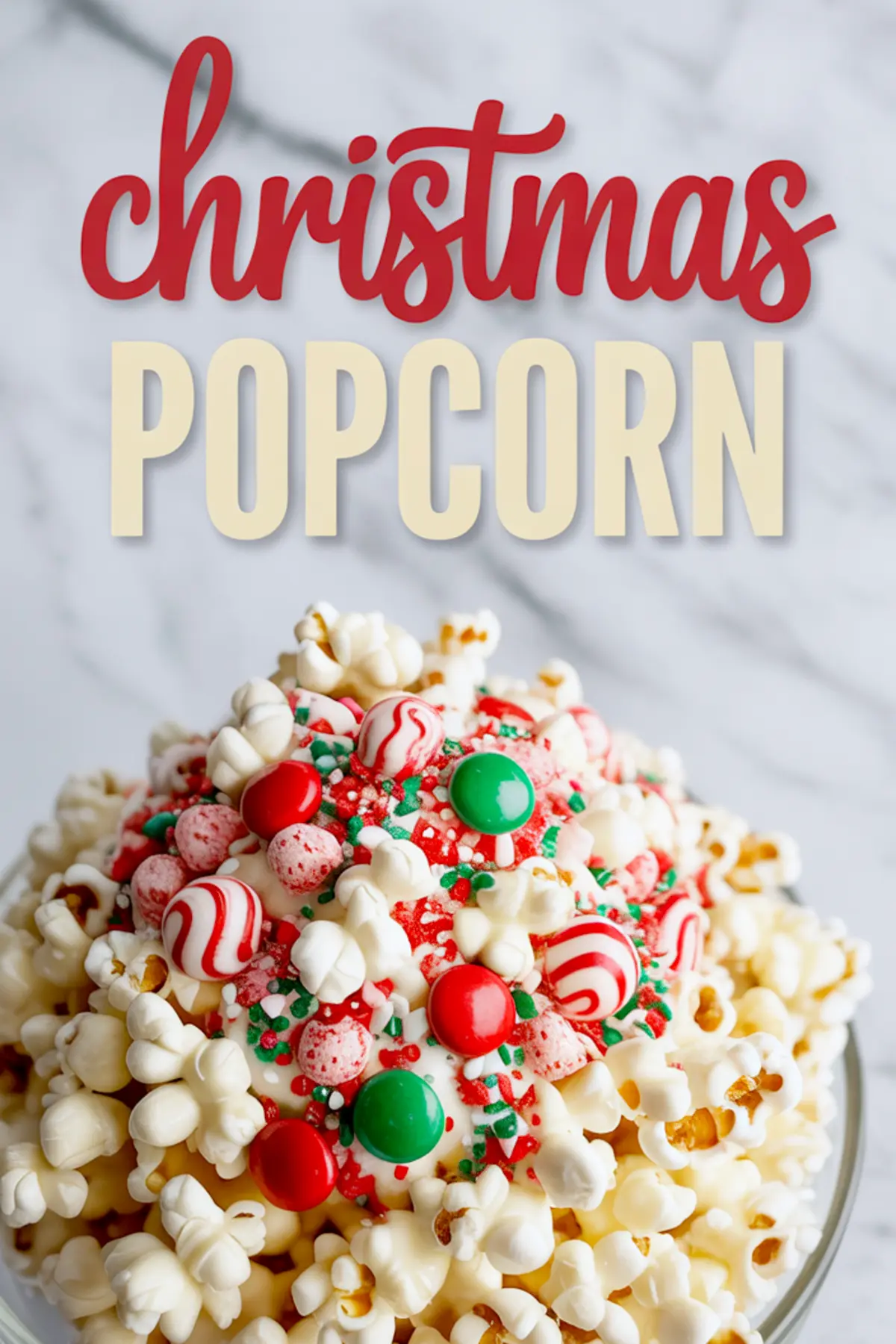 A close-up of a festive bowl of Christmas popcorn coated in white chocolate and topped with red and green candies, peppermint swirls, and holiday sprinkles, with a "Christmas Popcorn" text overlay above.