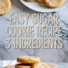 Golden sugar cookies on a plate and stacked cookies on a white dish, styled over marble with “easy sugar cookie recipe 3 ingredients” text in bold lettering.