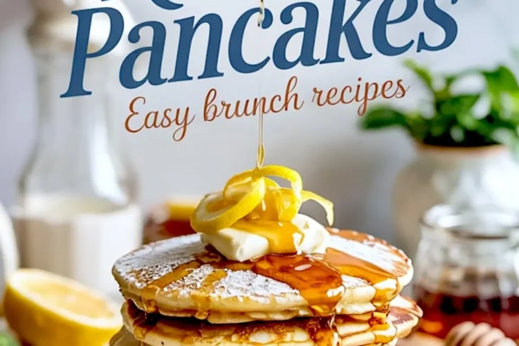 Stack of lemon ricotta pancakes drizzled with syrup and topped with butter and lemon zest, with a honey dipper and sliced lemons in the background on a marble surface.