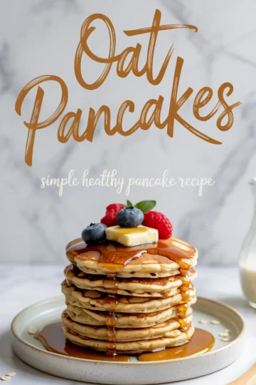 Stack of fluffy oat pancakes topped with butter, syrup, blueberries, raspberries, and a mint leaf on a beige plate with a marble background.