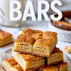 Alt text: Stack of golden snickerdoodle bars on a plate with visible cinnamon crust and soft, chewy center, styled with text reading “Snickerdoodle Bars” in bold lettering.