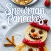 Collage of festive snowman pancakes made with three stacked pancakes decorated with chocolate candies, powdered sugar, red fruit leather scarf, pretzel stick arms, and an orange candy nose on a white marble background.