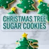Decorated Christmas tree sugar cookies with green icing, yellow star toppers, and colorful sprinkles, arranged on crinkled parchment paper and stacked on a white plate, with text overlay reading “CHRISTMAS TREE SUGAR COOKIES.”