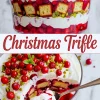 Collage showing a Christmas trifle dessert with layers of whipped cream, berry compote, pistachios, and sponge cake cubes, topped with fresh cranberries and mint; bottom half shows a spoonful scooped out revealing berry-soaked layers.