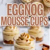 Glass dessert cups filled with layers of crushed cookies and eggnog mousse, topped with piped whipped cream and sprinkled with cinnamon.