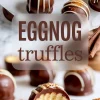 Overhead view of chocolate-coated eggnog truffles with white drizzle and crumb topping, with large “Eggnog Truffles” text overlay in bold font.