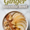 Overhead view of a pear ginger smoothie bowl topped with thin pear slices, chopped candied ginger, walnuts, and ground cinnamon, placed on a light marble surface with text above reading “Pear Ginger Smoothie Bowl.”