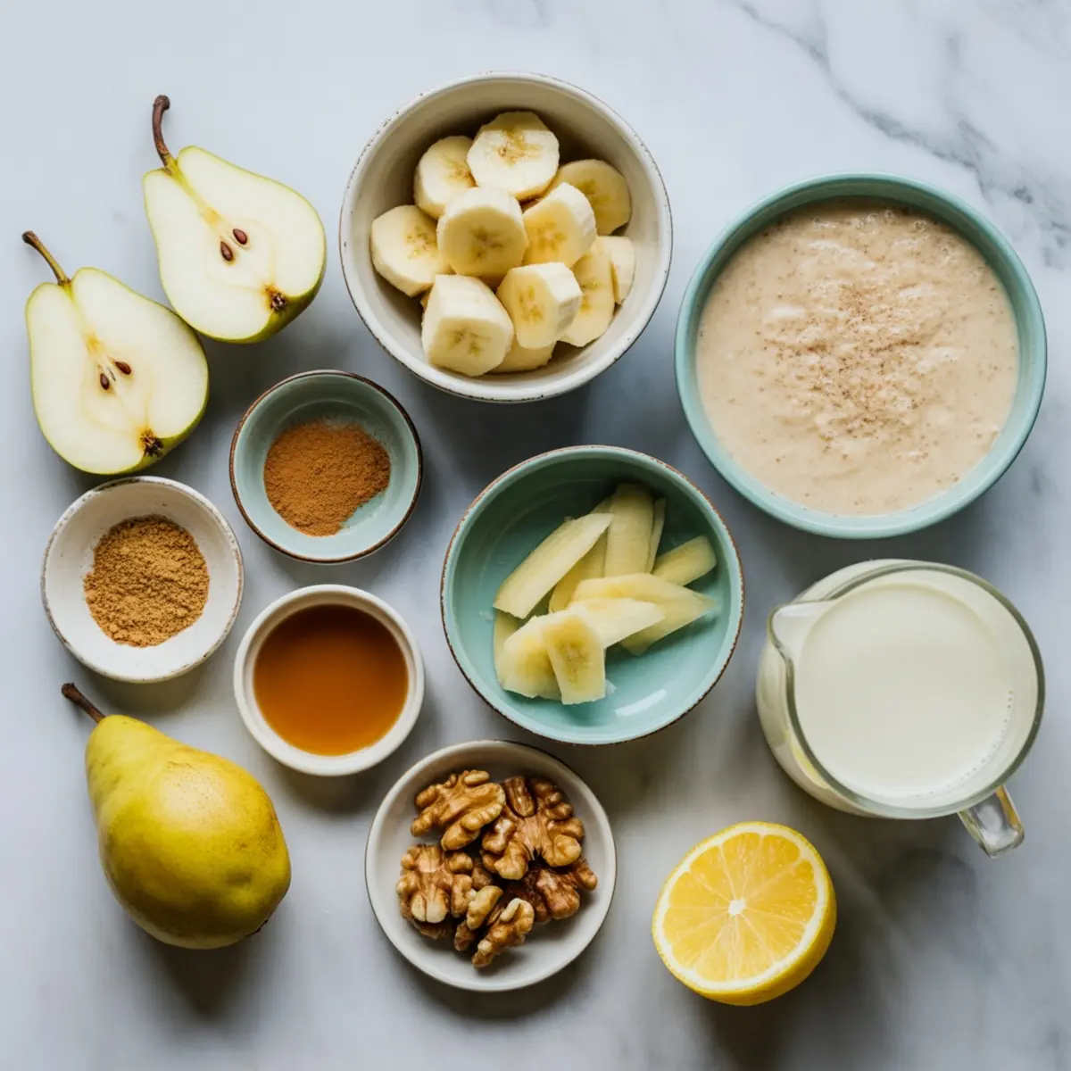 Flat lay of pear ginger smoothie ingredients including sliced bananas, halved pears, ginger, lemon, walnuts, cinnamon, maple syrup, and milk in ceramic bowls on a marble background.