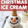 Vanilla ice cream scoops stacked to resemble a snowman, decorated with chocolate candies and orange nose, topped with a waffle cone hat, labeled “Christmas Ice Cream.”